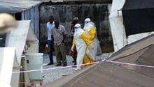 Du personnel sanitaire sortent d’un centre de quarantaine pour des personnes infectées à Conakry. © AFP