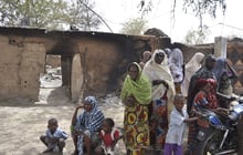 Des femmes et des enfants près d’une maison incendiée par Boko Haram, le 26 mai 2015. © Jossy Ola/AP/SIPA