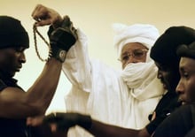 L’ancien président tchadien Hissène Habré est escorté par ses gardiens de prison dans la salle du tribunal à Dakar pour son procès le 20 juillet 2015. © Seyllou/AFP