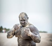 Bombardier s’entraîne à la lutte à la plage à Mbour. Il est parfois dur avec ses partenaires d’entraînement. © Sylvain Cherkaoui pour JA