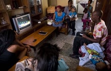 Une famille sud-africaine regarde la retransmission de l’enterrement du Président Nelson Mandela le 15 décembre 2013 à Johannesburg. © Matt Dunham/AP/SIPA