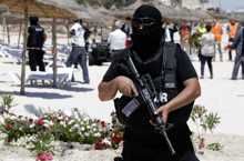 Un policier tunisien monte la garde sur la plage où a eu lieu l’attaque terroriste à Sousse, en juin 2015 (illustration) © Abdeljalil Bounhar/AP/SIPA