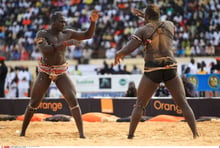 Senegal Wrestling to Riches © In this Sunday, May 30, 2010 photo, Senegalese traditional wrestler L’an 2000 (French for ‘The Year 2000’), left, faces off against his opponent Super Etoile (‘Super Star’) during a weekly wrestling match in Dakar, Senegal. Thousands of unemployed or underemployed men flock to this West African country’s capital to train in wrestling schools in the hopes of making it big. Those who succeed rake in tens of thousands of dollars every time they step in the ring.(AP Photo/Olivier Asselin)/Senegal_Wrestling_to_Riches_SEN111/MADE AVAILABLE FRIDAY JULY 23 2010/1007231601