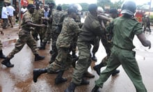 Des policiers guinéens arrêtent un manifestant devant le stade de Conakry, le 28 septembre 2009. © Seyllou Diallo/AFP