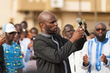 Kemi Seba brûlant un billet de 5 000 FCFA lors d’un rassemblement, le 19 août 2017 à Dakar. © Clément Tardif pour J.A.