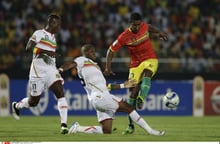 Le capitaine de l’équipe de foot du Mali, Yacouba Sylla (au centre), face au guinéen Kevin Constant, lors de la CAN 2015. (Archive) © Themba Hadebe/AP/SIPA