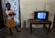 Une fillette à côté d’un écran de télé, à Cherif Lo, près de Tivaouane au Sénégal, en 2005. © SCHALK VAN ZUYDAM/AP/SIPA