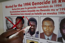 Jean Claude Ndatabaye, secrétaire administratif de l’Unité de suivi des fugitifs du génocide, barre la photo d’Augustin Bizimana, l’un des fugitifs les plus recherchés du génocide des Tutsi au Rwanda, le 22 mai 2020. © Jean Claude Ndatabaye, administrative secretary of the Genocide Fugitive Tracking Unit, draws a red cross on the face of Augustin Bizimana, one of the most-wanted fugitives from the 1994 Rwandan genocide, on a wanted poster at their office in Kigali, Rwanda, on May 22, 2020. – On May 22, 2020, the United Nations (UN) tribunal said it had at an unknown date come into possession of human remains from a grave site in Pointe Noire in the Republic of the Congo. Extensive analysts showed that Bizimana had died in 2000 after all. The news dashed the hopes of victims for justice, just days after the arrest of Felicien Kabuga, one of the last fugitives from the genocide, who had been on the run for three decades. (Photo by Simon Wohlfahrt / AFP)