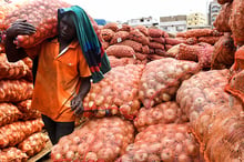 Un vendeur transporte des sacs d’oignons sur le marché de Camberene, à Dakar, le 2 juin 2019, © Seyllou / AFP.