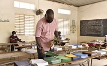 Un électeur dans un bureau de vote de Dakar lors des élections municipales du 23 janvier 2022. A voter picks a ballot paper at a voting station in Dakar, on January 23, 2022, during the 2022 municipal elections in Senegal. – Voters in Senegal went to the polls on Sunday to elect mayors and local representatives in a vote seen as a key test of support for President Macky Sall. The election is the first in the West African country since deadly riots erupted last year following the arrest of opposition leader Ousmane Sonko © SEYLLOU/AFP