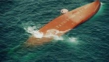 Photo aérienne prise par la Marine nationale française de l’épave retournée du Joola avant qu’il ne sombre, avec un canot de sauvetage lancé par un avion militaire français à son flanc, prise le 27 septembre 2002. © AFP