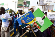 Des manifestants de l’opposition sénégalaise tiennent des photos de l’ancien ministre Karim Wade et du maire de Dakar Khalifa Sall lors d’une marche pour exiger la transparence des élections à Dakar, le 29 novembre 2018. © SEYLLOU / AFP