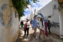Des touristes dans les allées de la Hara Kebira, le principal quartier juif de l’île de Djerba, où se trouve la synagogue de la Ghriba, à la suite d’une fusillade perpétrée par un policier sur l’île du sud de la Tunisie, le 10 mai 2023. © FETHI BELAID / AFP
