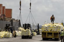 Déchargement de sacs de riz transportés par un navire en provenance d’Asie, le 27 mars 2019, au port d’Abidjan. Workers unload bags of rice carried by a ship from Asia on March 27, 2019 in the harbour of Abidjan. © ISSOUF SANOGO / AFP