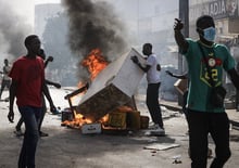 Des supporters de candidats à l’élection présidentielle de l’opposition brûlent des pneus et des meubles lors d’un rassemblement en contestation au report du scrutin, à Dakar, le 4 février 2024. © Cem Ozdel / Anadolu via AFP