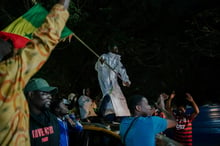 Un Sénégalais sur le toit de sa voiture brandissant le drapeau sénégalais pendant l’élection présidentielle. © Carmen Abd Ali / AFP