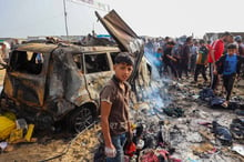 Palestiniens rassemblés sur le site de la frappe israélienne sur un camp de personnes déplacées à Rafah, le 27 mai 2024. © Eyad Baba / AFP