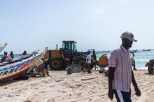 Un engin de terrassement transporte les corps de migrants ayant péri dans un naufrage au large de la Mauritanie, sur une plage près de Nouakchott, le 24 juillet 2024. © Med LEMIN RAJEL / AFP