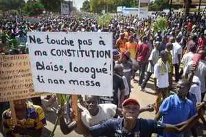 Des partisans de l’opposition du Burkina Faso participent à une manifestation le 28 octobre 2014 à Ouagadougou contre une proposition d’amendement de la constitution visant à prolonger les 27 ans de règne du président Blaise Compaoré. © AFP PHOTO/ISSOUF SANOGO