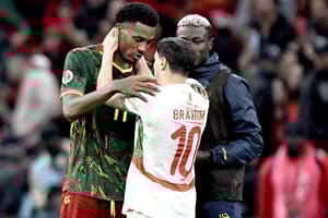 L’attaquant marocain Brahim Diaz (au centre) discute avec le défenseur camerounais Samuel Kotto (à gauche) à l’issue des quarts de finale de la CAN, au stade Prince-Moulay-Abdellah de Rabat, le 9 janvier 2026.