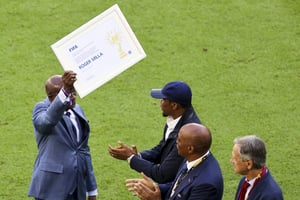 L’ancien joueur camerounais Roger Milla reçoit un prix spécial de la Fifa lors de la Coupe du monde 2022 au Qatar. © Serhat Cagdas / Anadolu Agency via AFP