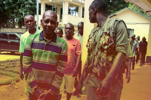 Le pasteur autoproclamé Paul Nthenge Mackenzie (à gauche), entouré d’officiers de la police kenyane et d’autres accusés lors de sa comparution au tribunal de Shanzu, à Mombasa, le 18 janvier 2024. © AFP