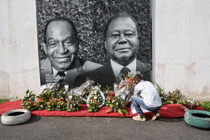 Devant la maison du Parti démocratique de Côte d’Ivoire (PDCI), le 12 août 2023, avec les portraits des deux anciens présidents décédés, Félix Houphouët-Boigny (à gauche) et Henri Konan Bédié (à droite).