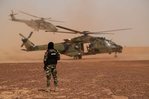 Un soldat de l’Unité spéciale d’intervention de la gendarmerie nationale (USIGN) française devant un hélicoptère NH90 Caïman, sur la base militaire de Ouallam, Niger, le 15 juillet 2022. © BERTRAND GUAY/AFP