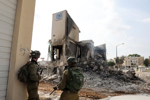 Des soldats israéliens se tiennent devant un commissariat de police d’où ont été délogés des combattants du Hamas, le 8 octobre 2023. © JACK GUEZ / AFP.