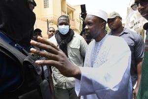 L’opposant sénégalais Ousmane Sonko avec des membres de la police devant sa résidence à Dakar, le 17 juin 2022. © SEYLLOU/AFP
