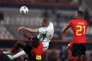 Le capitaine algérien Islam Slimani qui dispute le ballon à deux joueurs angolais lors de la Coupe d’Afrique des nations © KENZO TRIBOUILLARD / AFP