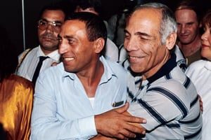Charlie Biton (à gauche), chef de la délégation israélienne pour les pourparlers de paix avec les hauts responsables de l’OLP à Budapest, reçoit une accolade de Latif Dori lors de son arrivée à Tel-Aviv, le 14 juin 1987. © Sven Nackstrand / AFP