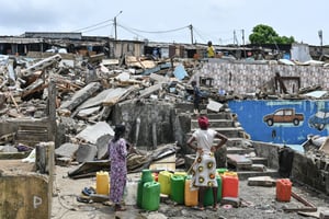 Des habitants viennent récolter de l’eau au travers des ruines dans le quartier d’Attecoube, à Abidjan, après la destruction du quartier. © ISSOUF SANOGO/AFP