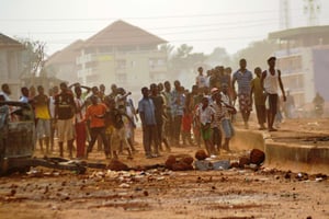 Des manifestants jettent des pierres sur les forces de sécurité lors d’une manifestation contre le manque d’électricité en Guinée, dans la commune de Tombolia, le 18 février 2014. © CELLOU DIALLO/AFP
