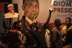 Des partisans de Bassirou Diomaye Faye célèbrent le dépouillement des votes au siège de sa coalition, à Dakar, le 24 mars 2024. © JOHN WESSELS / AFP