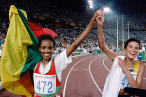 L’Éthiopienne Derartu Tulu (à g.) et la Sud-Africaine Elana Meyer, respectivement médaille d’or et d’argent du 10 000 mètres aux JO de Barcelone, célèbrent leur victoire lors d’un tour de piste fraternel, le 7 août 1992. © Pascal Pavani/AFP