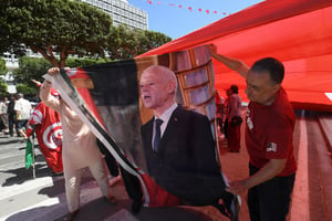 Des partisans du président tunisien Kais Saïed brandissent son image lors d’un rassemblement le long de l’avenue Habib Bourguiba à Tunis, le 25 juillet 2024 © FETHI BELAID/AFP