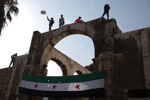 Des Syriens brandissent le drapeau de l’indépendance, dans la capitale, Damas, le 20 décembre 2024. © OMAR HAJ KADOUR / AFP