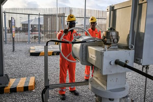 Deux employés d’Eni après la mise en service du nouveau champ pétrolier et gazier, exploité par le géant italien de l’énergie et son partenaire Petroci à Port-Bouët, dans la banlieue d’Abidjan, le 23 novembre 2023. © SIA KAMBOU/AFP