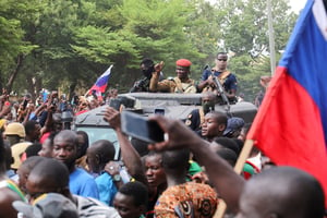 Ibrahim Traoré, est accueilli par des partisans brandissant des drapeaux russes alors qu’il arrive à la télévision nationale à bord d’un véhicule blindé à Ouagadougou, le 2 octobre 2022. © REUTERS/Vincent Bado