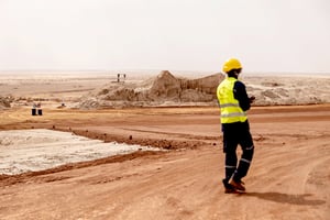 Le 8 mars 2023, un mineur marche sur le terril de la mine de Cominak, près d'Arlit. La société minière Akouta (Cominak), exploitée dans la ville d'Akokan, près d'Arlit, par le groupe français Areva (aujourd'hui Orano), a débuté ses activités en 1978. Elle a fermé ses portes en 2021, suite à l'épuisement de ses réserves après avoir produit 75 000 tonnes d'uranium. Sa réhabilitation, d'un coût de 150 millions d'euros, est en cours et devrait durer dix ans, suivie d'au moins cinq années de surveillance environnementale.