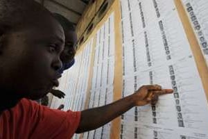 Des habitants d’Abidjan cherchent leur nom sur la liste électorale provisoire © AFP