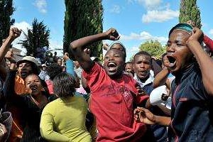 Alors que les assassins de Terreblanche comparaissent au tribunal, la foule scande l’hymne national. © Alexander Joe / AFP