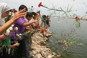 Des Palestiniens jettent des fleurs dans le port de Gaza, mardi 1er juin, en hommage aux victimes. © AFP