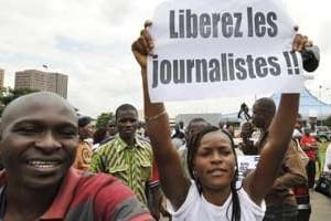 Une journaliste ivoirienne manifeste pour la libération de ses trois confrères, le 23 juillet. © AFP