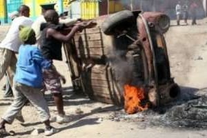 Des manifestants retournent une voiture brûlée à Maputo, le 2 septembre 2010. © AFP