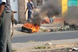 Un policier près d’un pneu incendié dans les rues de Maputo, le 2 septembre 2010 au Mozambique. © AFP