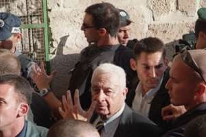 Le 28 septembre, un agent protège Ariel Sharon des jets de pierre, sur l’Esplanade des Moquées. © Reuters