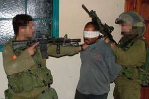 Des soldats israéliens pointent leurs armes sur un prisonnier. © Breaking the silence/AFP