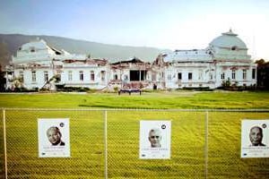 Affiches électorales devant les ruines du palais présidentiel. © Sipa